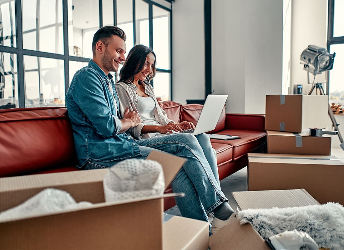 Personal Insurance - Young Couple Moving Into a New Condo With Boxes All Around the Floor